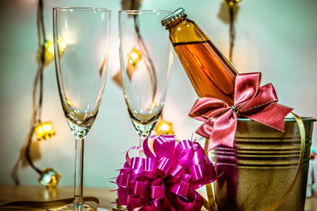 Cold champagne and glass ready for holiday with a candle on a candlestick for the Christmas and New Year festival.
