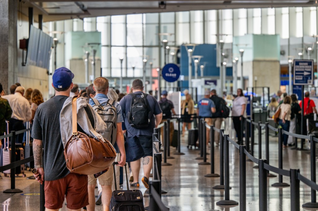 Passengers waiting in line in airport security.