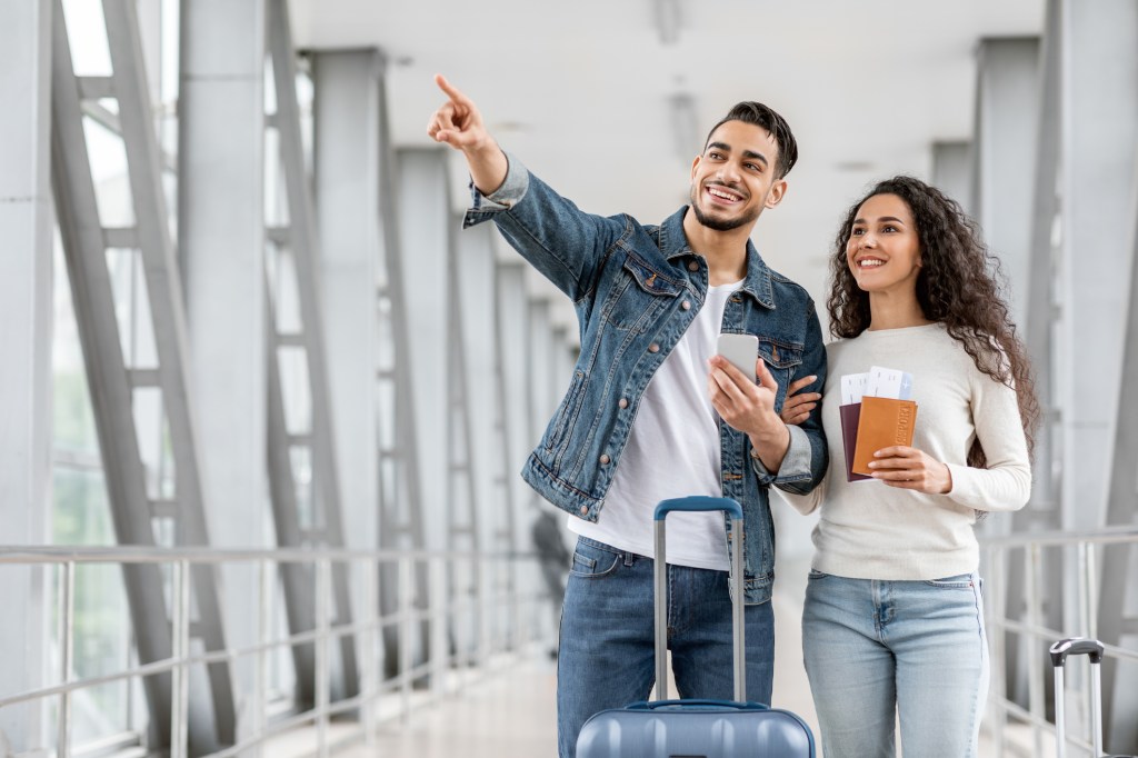 Young couple staying at the airport with luggage