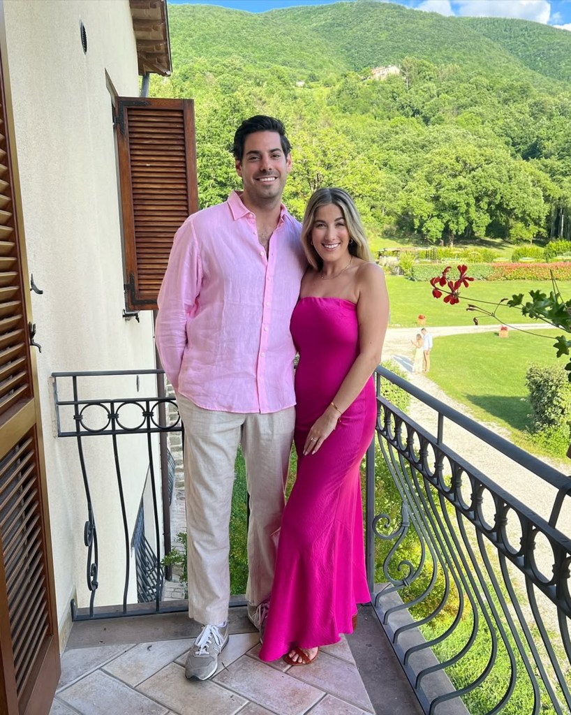 Couple on a balcony overlooking a mountain landscape.