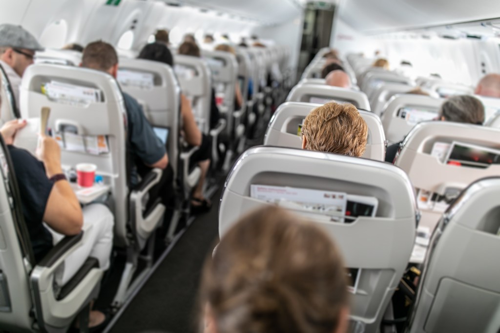 Passengers sitting on a commercial plane.