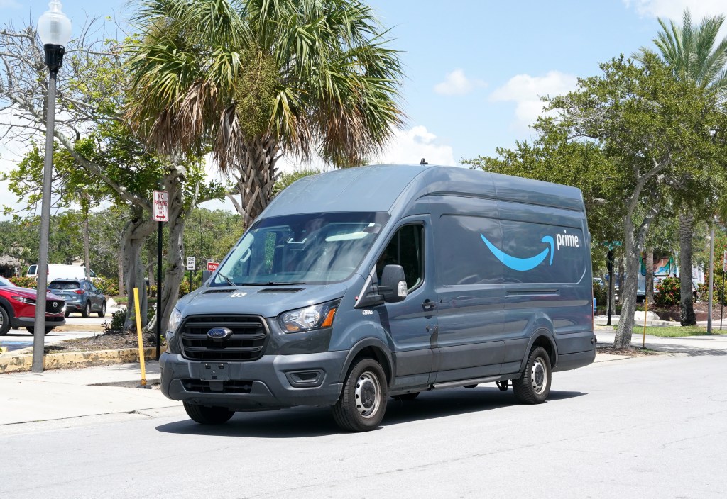 Prime Minister Amazon's distribution van by driving a road.